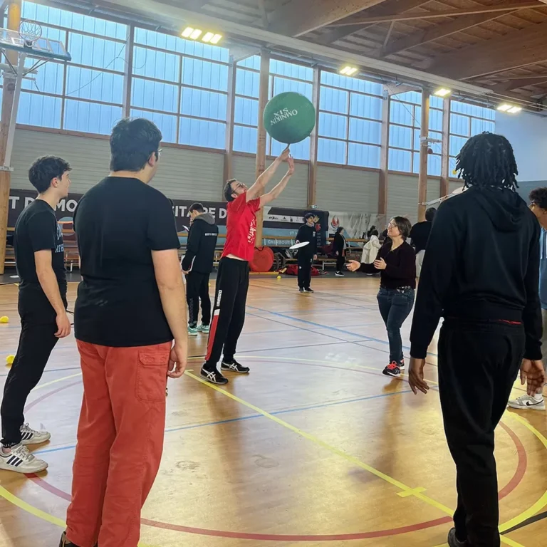 Personnes jouant au dodgeball en gymnase.